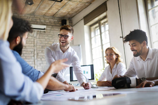 team of employees communicating around the table about Online Assessment Tests