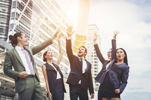 A team of happy employees celebrating a great result from working together to achieve success