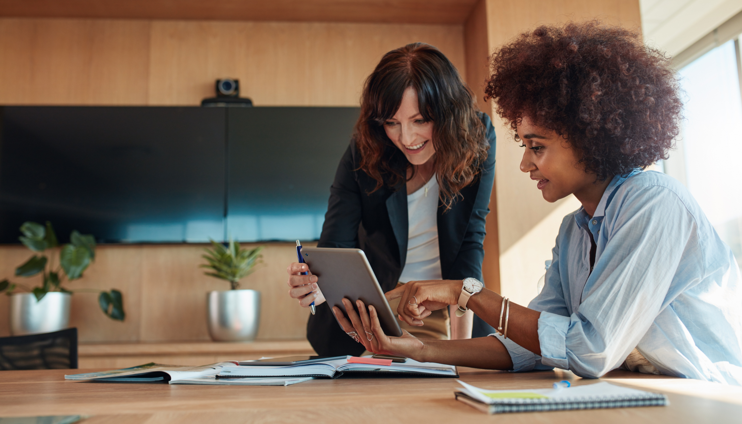 employee engagement of two employees talking to each other over a tablet showing some technology while communicating
