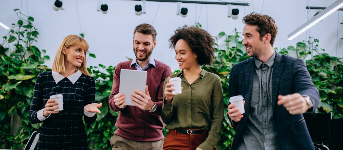 Group of coworkers walking and looking at a digital tablet