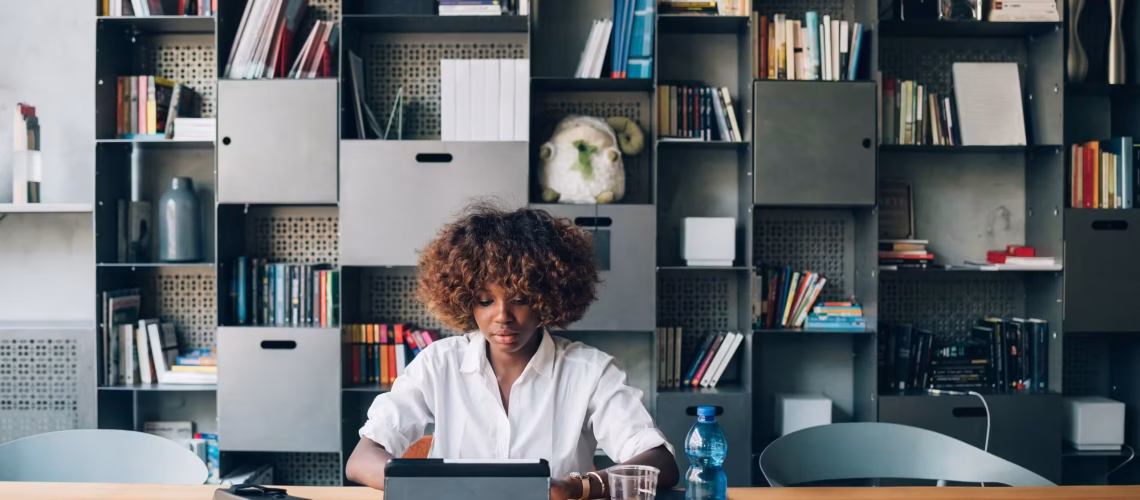 young black student working with tablet on a project in coworkin