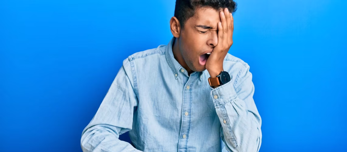 tired overwork Young handsome african american man wearing casual clothes sitting on the table yawning tired covering half face, eye and mouth with hand. face hurts in pain.