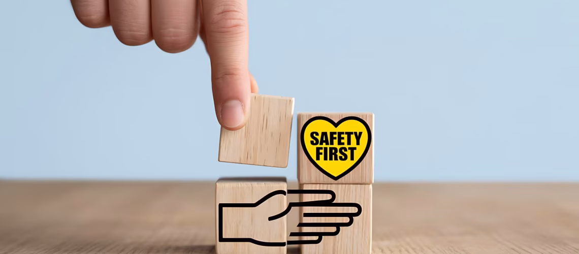 Hand building "Safety First" concept with wooden blocks, representing teamwork, security, and protection