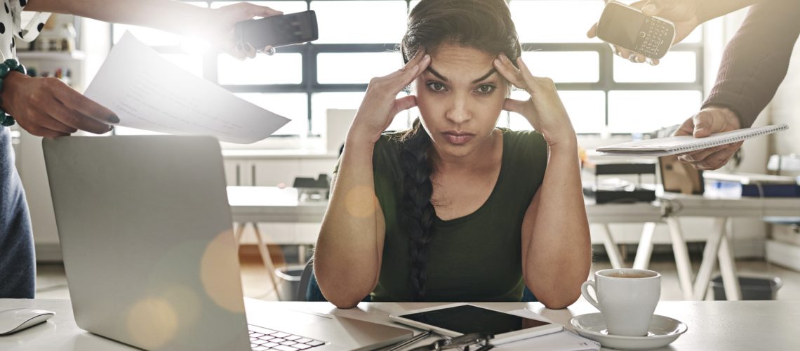 stressed out businesswoman surrounded by colleagues needing help overworked no support wellbeing mental health wellness