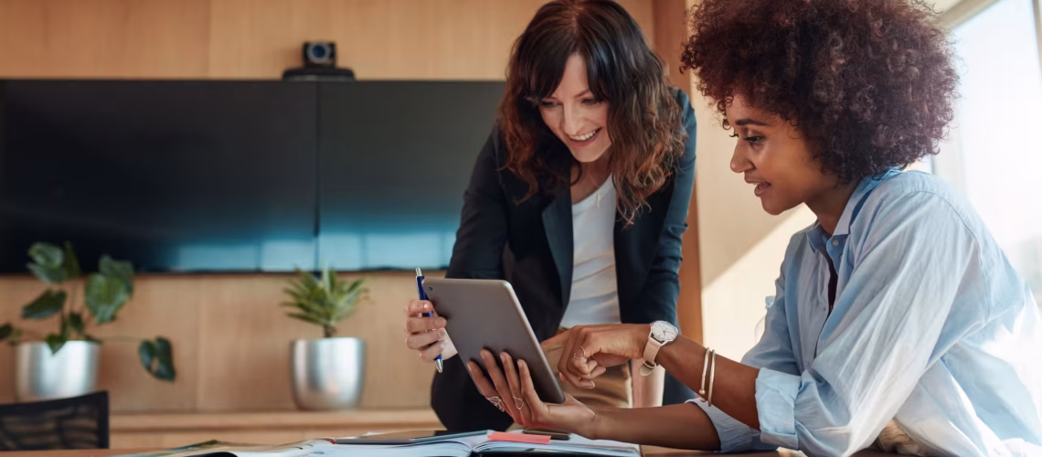 employee engagement of two employees talking to each other over a tablet showing some technology while communicating