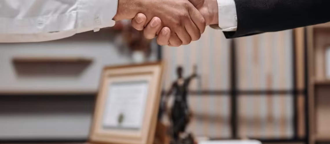 handshake of two legal lawyers talking on termination disputes and reaching a settlement